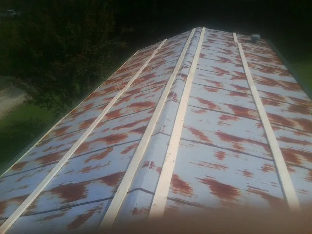 Rusted metal roof panels with new wood purlins before replacement — Storm Damage Roof Repair in Marengo by Roofing Brothers